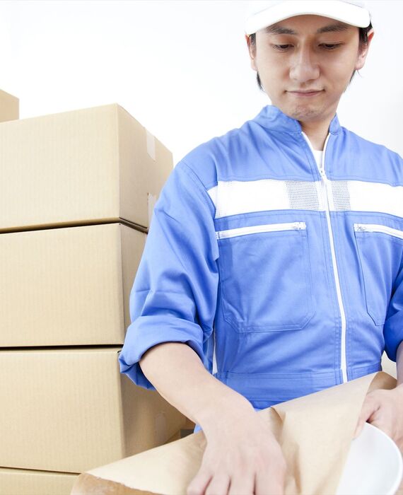 お皿の梱包をする引っ越し業者